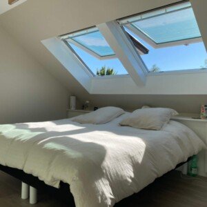 Chambre parentale sous combles à Serris – un espace lumineux et apaisant signé Moreno Création. Chambre parentale aménagée sous combles à Serris avec fenêtres Velux et isolation soignée – Moreno Création