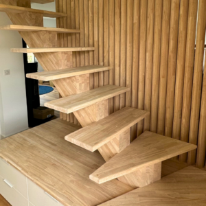 Escalier sur mesure en hévéa avec claustra et rangements intégrés – une réalisation signée Moreno Création. Escalier à limon central en hévéa avec claustra et agencement intégré fabriqué par Moreno Création