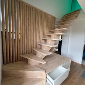 Escalier à limon central en bois avec claustra à lames inclinées – création Moreno Création, design contemporain et rangement intégré. Escalier à limon central avec claustra à lames inclinées et rangement intégré fabriqué par Moreno Création