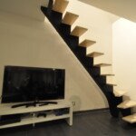 Escalier à limon central teinte noire – alliance du métal et du bois par Moreno Création. Escalier sur mesure à limon central avec quart tournant bas et limon noir effet acier fabriqué par Moreno Création à Louvres