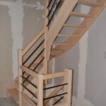 Escalier sur mesure bois et métal – alliance du hêtre massif et de l’acier noir thermolaqué par Moreno Création. Escalier sur mesure sans contremarches à quart tournant du milieu avec lisses en acier thermolaqué noir fabriqué par Moreno Création à Soissons