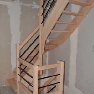 Escalier sur mesure bois et métal – alliance du hêtre massif et de l’acier noir thermolaqué par Moreno Création. Escalier sur mesure sans contremarches à quart tournant du milieu avec lisses en acier thermolaqué noir fabriqué par Moreno Création à Soissons