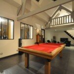 Espace sous combles avec charpente traditionnelle et escalier limon central – création lumineuse signée Moreno Création. Charpente traditionnelle sur mesure avec 8 châssis de toit et escalier limon central vers bureau sous les étoiles – Moreno Création